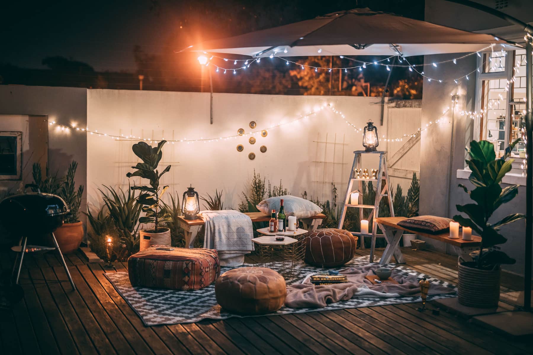 A flatwoven outdoor rug on a wooden deck with patio furniture