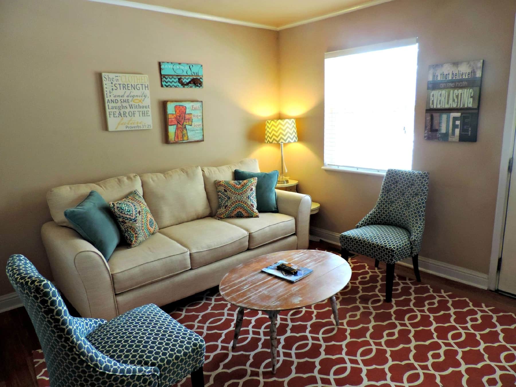 A large rug positioned under a sofa and armchairs showing furniture placement